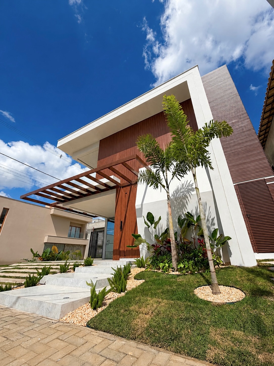 Fachada de residência contemporânea com madeira, palmeiras e jardim